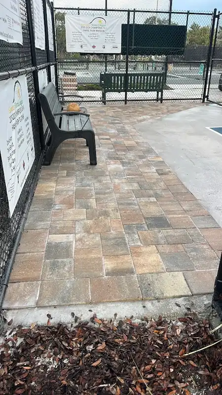 Completed paver walkway beside seating and sport court fencing at Payne Park in Sarasota, Florida