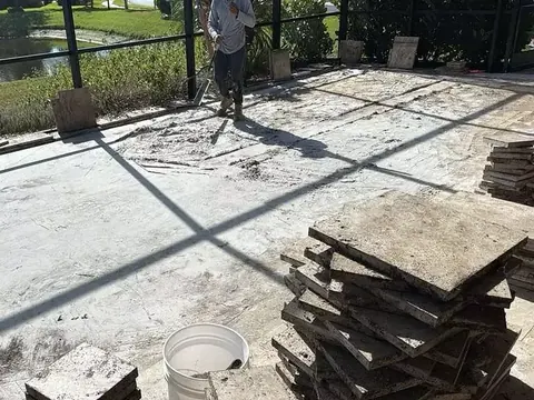 Paver lanai floor lifted for repair in Venice, Florida with pavers stacked for reset
